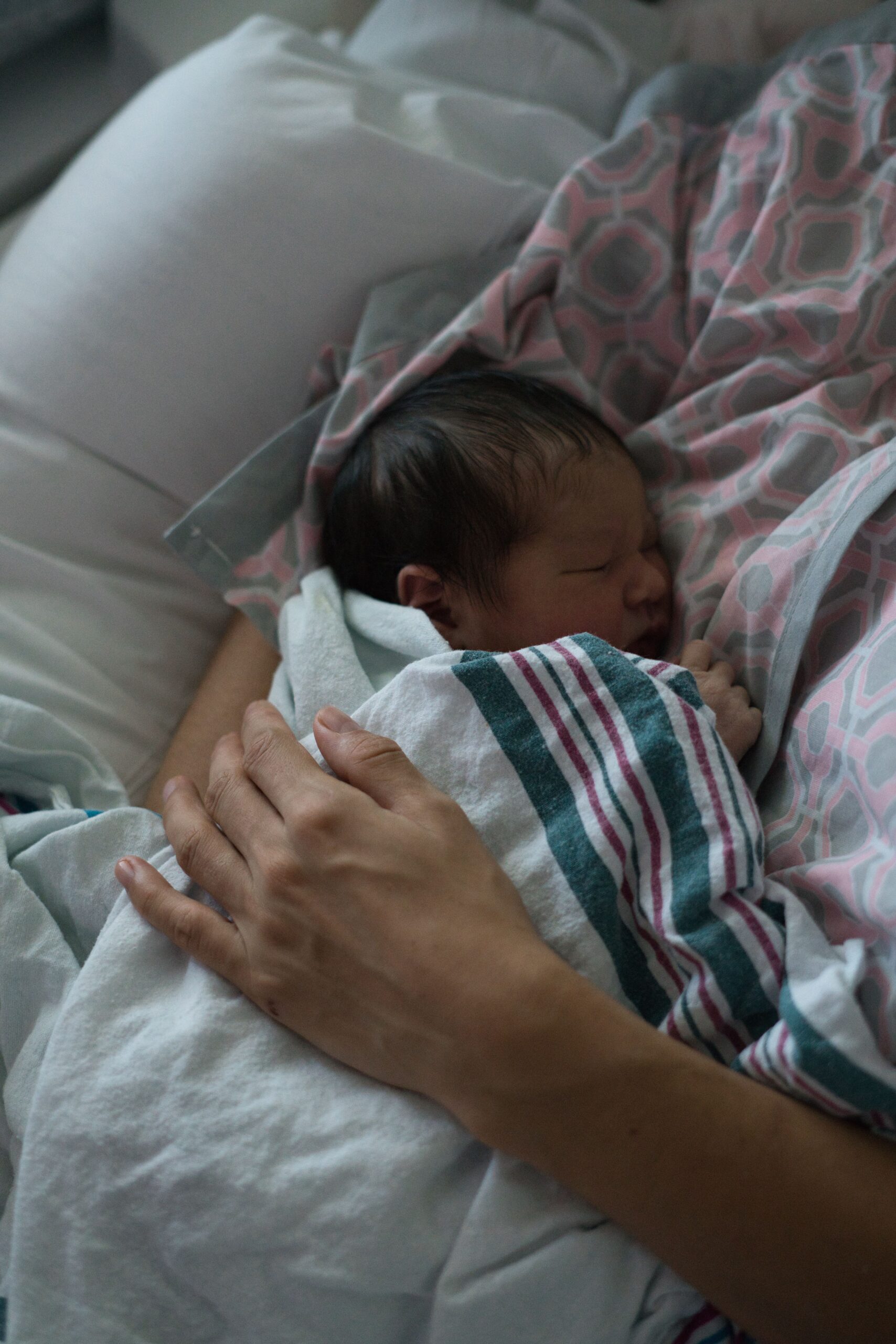 Nouveau-né endormi dans les bras d’un parent